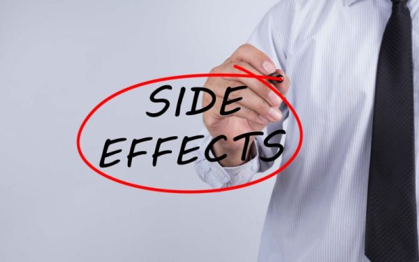 Person in business attire writing "SIDE EFFECTS" in red on a clear background, emphasizing common side effects of Lumecca IPL treatment.